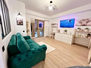 a living room with a green couch and a tv at Summer Studio in Constanţa