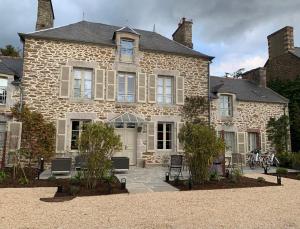 a large stone house with a white door at Le Berceul in La Richardais