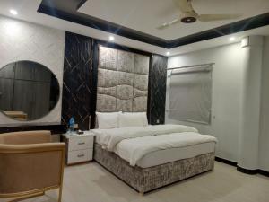 a bedroom with a large bed and a mirror at Grandy Boutique hotel in Islamabad