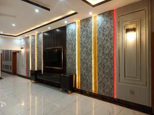 a living room with a tv and a wall at Grandy Boutique hotel in Islamabad