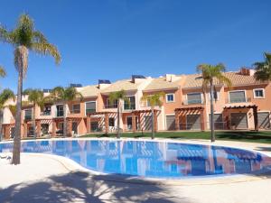 a swimming pool in front of a building with palm trees at Santa Maria N - Shared Pool - 8 Guests - Albufeira in Albufeira