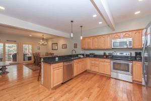 a kitchen with wooden cabinets and stainless steel appliances at Mystic Haven by Railey Vacations in Oakland +32 photos