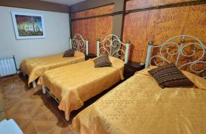 three beds in a room with yellow sheets at Hotel Aguilar in Uyuni +61 photos