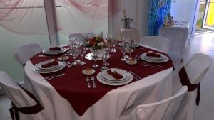 a table with white chairs and a red table cloth at Chacras de Sierra in Sierra de los Padres