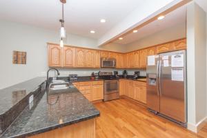 a kitchen with wooden cabinets and a stainless steel refrigerator at Mystic Haven by Railey Vacations in Oakland