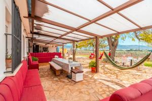 an outdoor patio with red couches and a hammock at Cubo's Cortijo La Olivera in Antequera