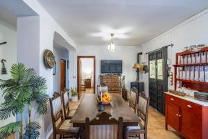 a dining room with a wooden table and chairs at Cubo's Cortijo La Olivera in Antequera