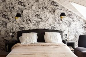 a bedroom with a bed with a floral wallpaper at Le Berceul in La Richardais