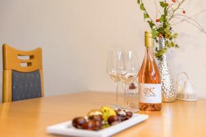 a bottle of wine and a plate of grapes on a table at Landhaus Krell in Mitterretzbach