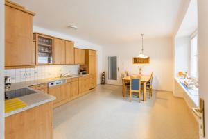 a kitchen with wooden cabinets and a table with chairs at Landhaus Krell in Mitterretzbach