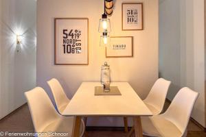 a table with white chairs and a vase on it at Luv und Lee in Schilksee +14 photos
