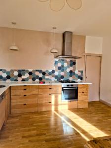a kitchen with wooden cabinets and blue and white tiles at Le Damier in Castres