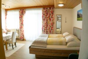 a bedroom with a bed and a table and a window at Appartement Isabella in Mieming