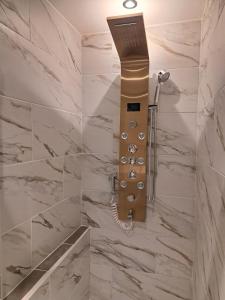 a shower in a bathroom with marble tiles at studio Saphyr in Souillac