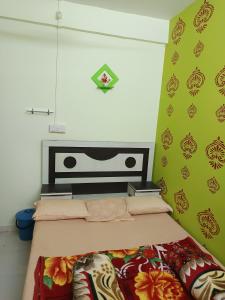 a bedroom with a bed with a green wall at Swami Inn Lodging in Trimbak