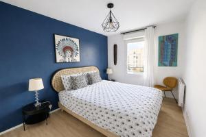 a bedroom with a bed with a blue wall at Charme et Douceur By UTA HOUSE in Saint-Denis