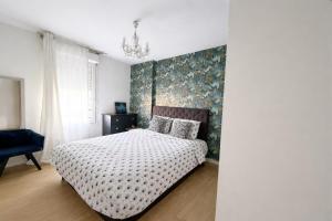 a bedroom with a bed with a floral accent wall at Charme et Douceur By UTA HOUSE in Saint-Denis