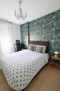a bedroom with a large bed with a floral wallpaper at Charme et Douceur By UTA HOUSE in Saint-Denis