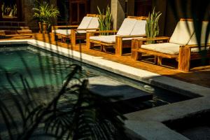 a group of lounge chairs and a swimming pool at Casona Tunan in Santa María Mizata