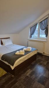 a bedroom with a bed with two towels on it at Aparthotel Metropol in Iaşi