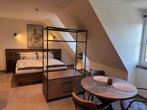 a bedroom with a bed and a table and chairs at Parzivita Suites in Wolframs-Eschenbach