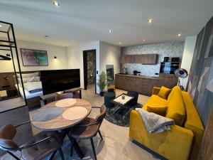 a living room with a yellow couch and a table at Parzivita Suites in Wolframs-Eschenbach