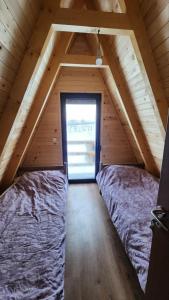two beds in a attic room with a window at Villa Qukapiku in Orllan