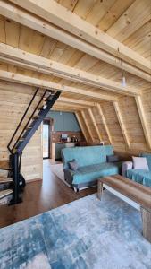 a living room with two blue couches and a staircase at Villa Qukapiku in Orllan