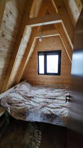 a bed in a wooden room with a window at Villa Qukapiku in Orllan