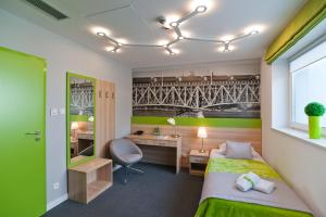 a hotel room with a bed and a desk and a desk at Green Hotel Płock in Płock