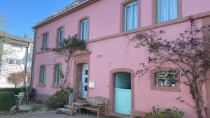 a pink building with a blue door and a bench at Das Blaue Haus - jetzt mit Sauna in Pirmasens