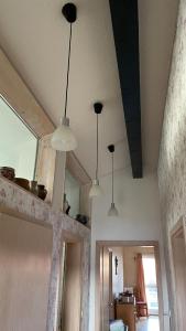 three lights hanging from the ceiling in a room at Das Blaue Haus - jetzt mit Sauna in Pirmasens