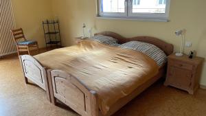 a large wooden bed in a bedroom with a window at Das Blaue Haus - jetzt mit Sauna in Pirmasens