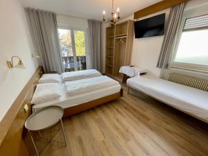 a hotel room with two beds and a tv at B&B Transit Rooms - Your Stopover, Free Parking in Vipiteno