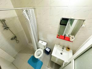 a bathroom with a toilet and a sink and a mirror at F2 Appart Les Ambassades Point E, Dakar in Dakar
