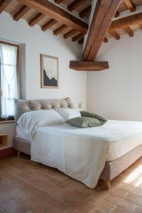 a bedroom with a large white bed with wooden ceilings at Terra dei Bisonti in Panicale