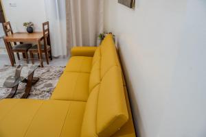 a yellow couch in a room with a table at F2 Appart Les Ambassades Point E, Dakar in Dakar