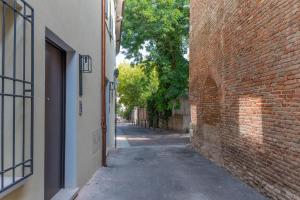 an alley with a brick wall and a building at Ca Moro Affittacamere - Residence Room Apartments in Rimini