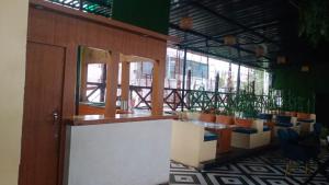 a room with a table and chairs and windows at Hotel Enigma in Indore