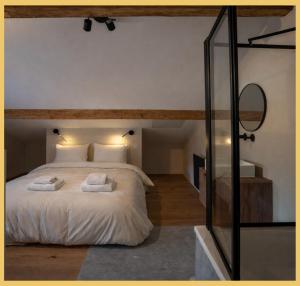 a bedroom with a large bed with two towels on it at Le Balcon du Mont-BIanc I Duplex I Combloux in Combloux