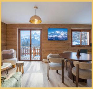 a living room with a table and views of mountains at Le Balcon du Mont-BIanc I Duplex I Combloux in Combloux