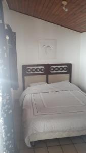 a bedroom with a large bed with white sheets at mini maison mini budget in Soulac-sur-Mer