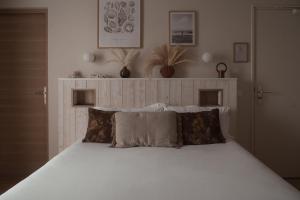 a bedroom with a bed with white sheets and pillows at Sézam Appart’Hôtel Saint-Malo in Saint Malo