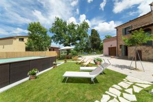 a backyard with a swimming pool and lawnitures at Tuscan Retreat Private Spa Villa in Lucignano