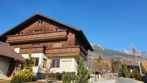 a large wooden house with a mountain in the background at Apartmány Villa Severka in Starý Smokovec