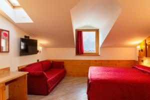 a living room with red furniture and a window at Hotel Ristorante Alla Nave in Lavis