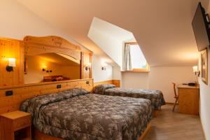 a bedroom with two beds in a room at Hotel Ristorante Alla Nave in Lavis
