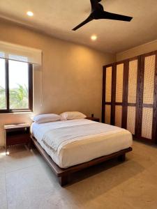 a bedroom with a bed with a ceiling fan at Luxury Apartment in Playa Blanca Zihuatanejo CAUMA in Zihuatanejo