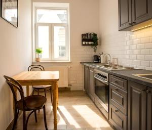 a kitchen with a table and a small table and chairs at Mid Apart Mennicza Cieszyn in Cieszyn