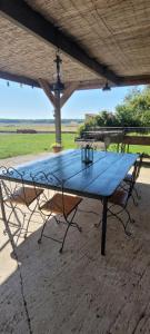 a blue picnic table with two chairs around it at Le Clos des chênes rouges in Corrobert